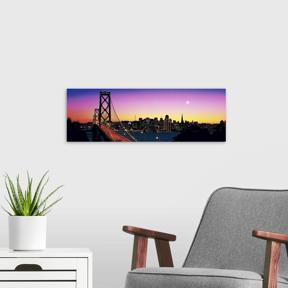 A modern room featuring Stunning panoramic photo of a suspension bridge in California at twilight, with a large city and ...