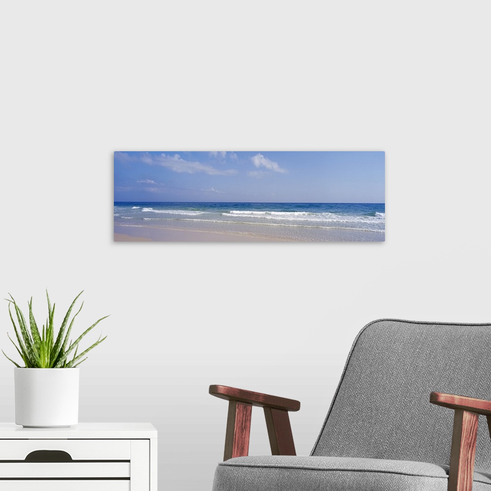 A modern room featuring Docor perfect for the home or office of a panoramic shot of a beach with waves coming in and a so...