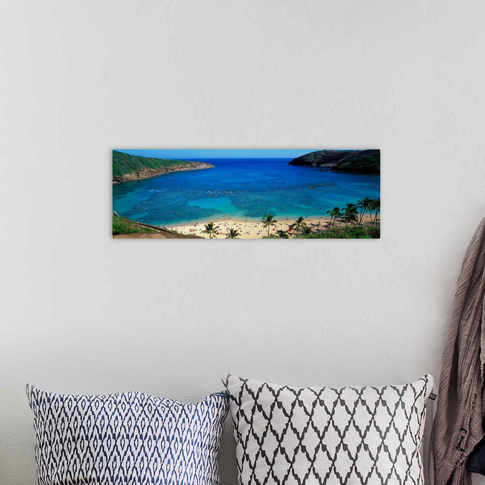 A bohemian room featuring High angle panoramic of a harbor on a tropical island and tourist sunbathing on the shore.