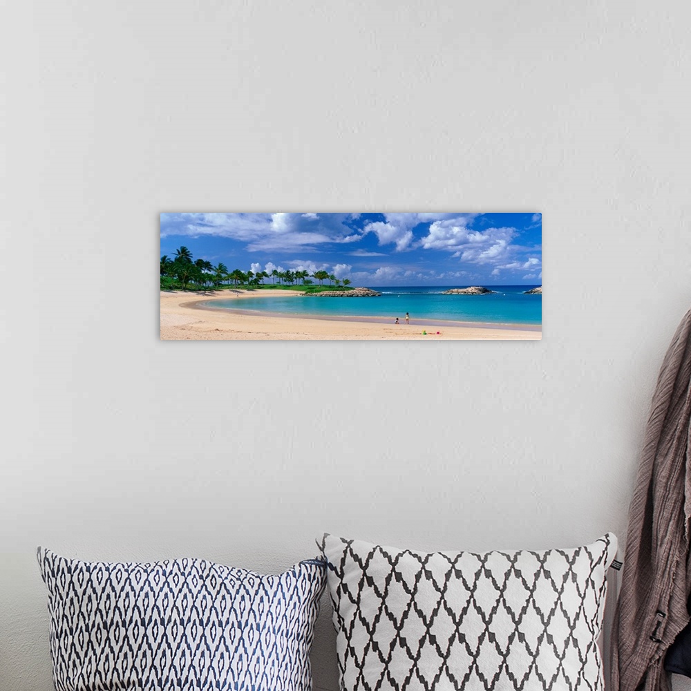 A bohemian room featuring A panoramic photograph of a tropical cover on an island lined with palm trees and clear water.