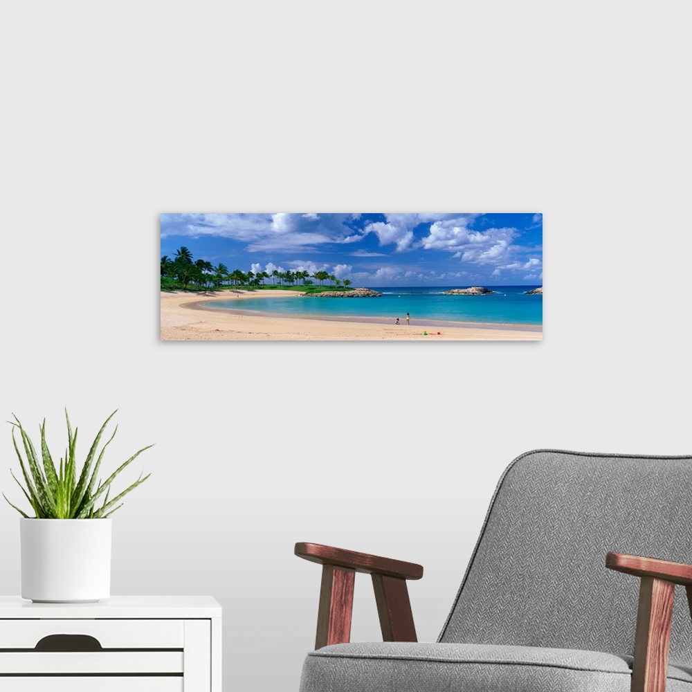 A modern room featuring A panoramic photograph of a tropical cover on an island lined with palm trees and clear water.