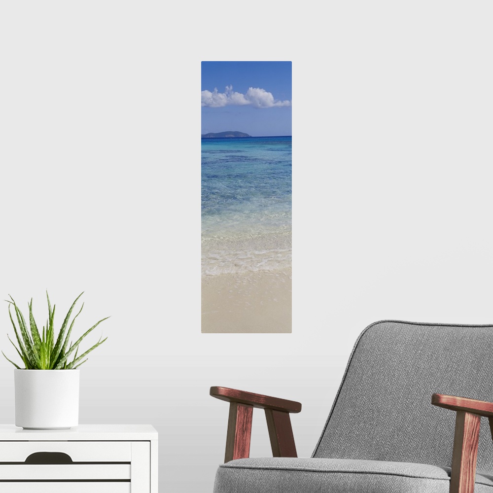 A modern room featuring Vertical panoramic photograph of ocean waves washing up to shore with an island in the distance u...