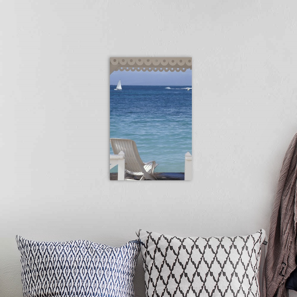 A bohemian room featuring Oversized, portrait photograph of beach chair beneath a canopy, looking toward clear blue ocean w...