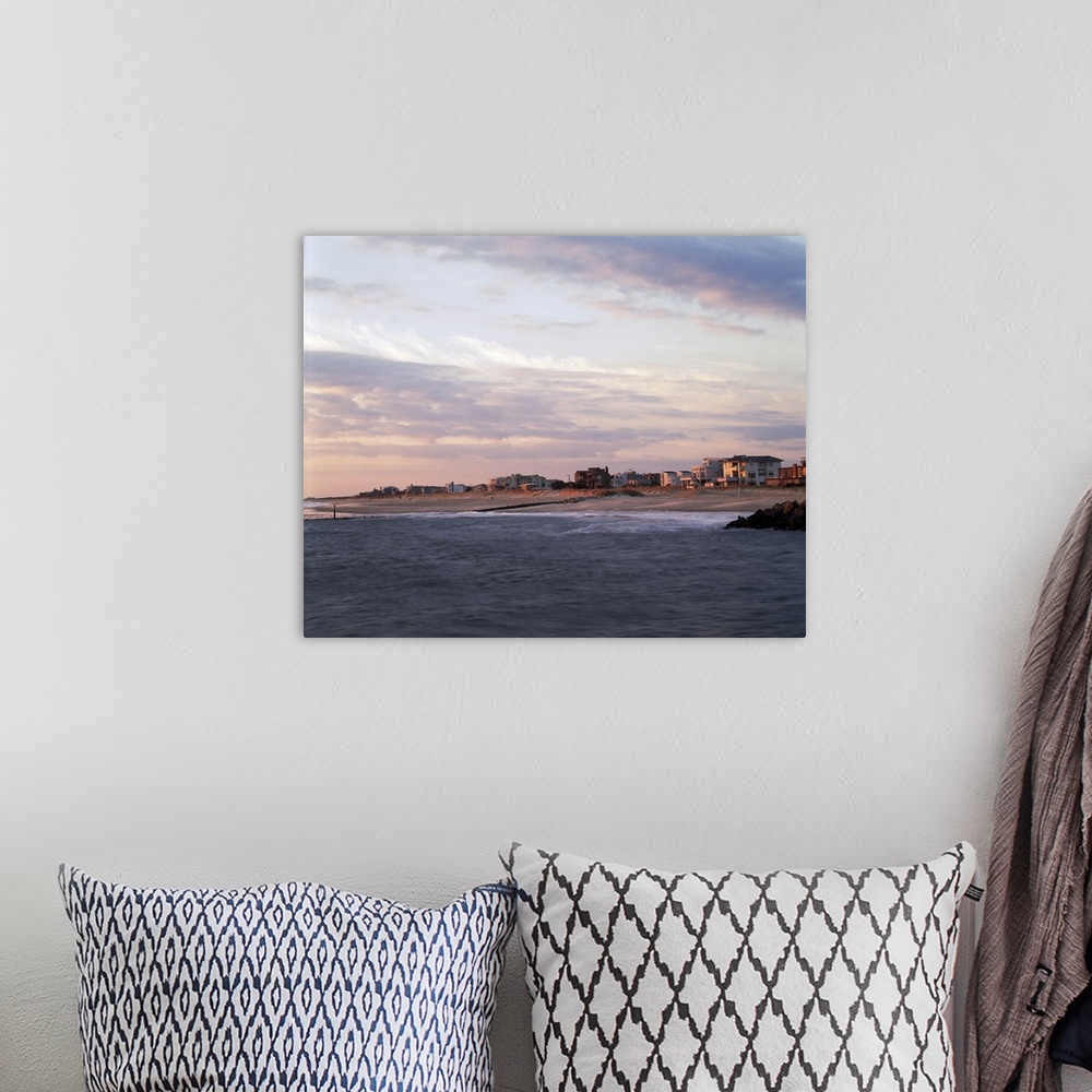 A bohemian room featuring This large piece is a photograph taken on the water looking at the beach coast that is lined with...