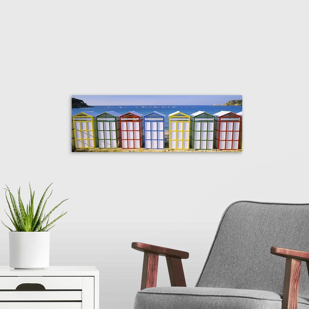 A modern room featuring Panoramic photograph of colorful row of huts on the shoreline with the ocean in the distance.