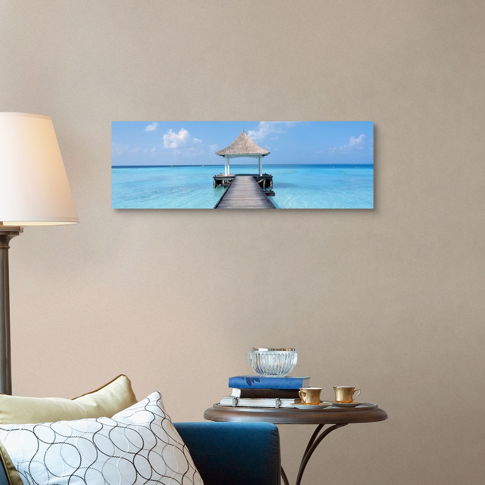 A traditional room featuring Oversized panoramic photograph of a pier extending into the crystal clear waters of the Maldives,...