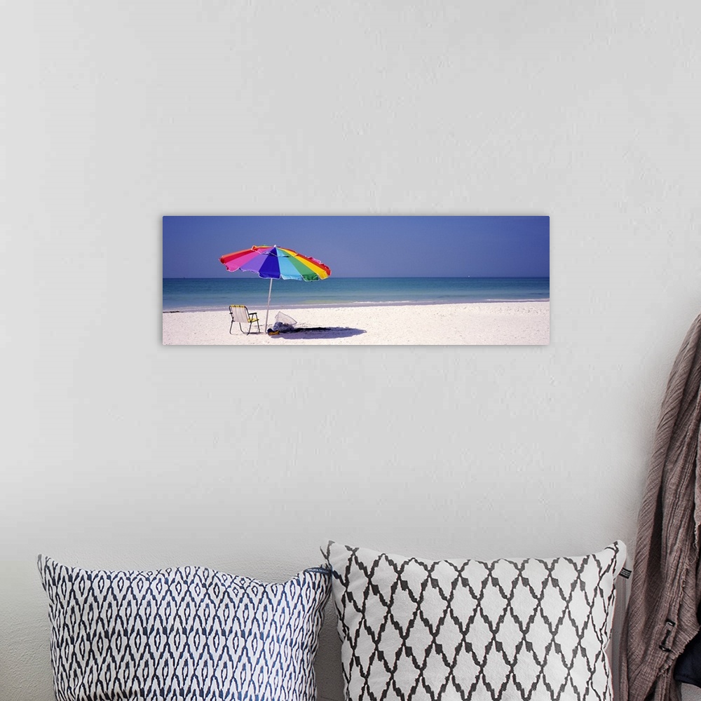 A bohemian room featuring Panoramic photograph of beach chair and parasol in the sand, with ocean fading into the distance....
