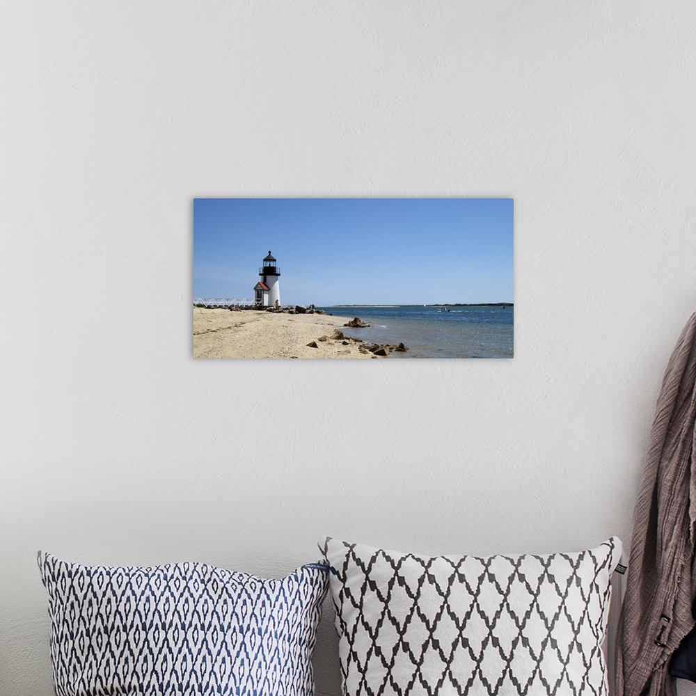 A bohemian room featuring Deocrative artwork for the home or office of a lighthouse sitting on the edge of the beach and th...