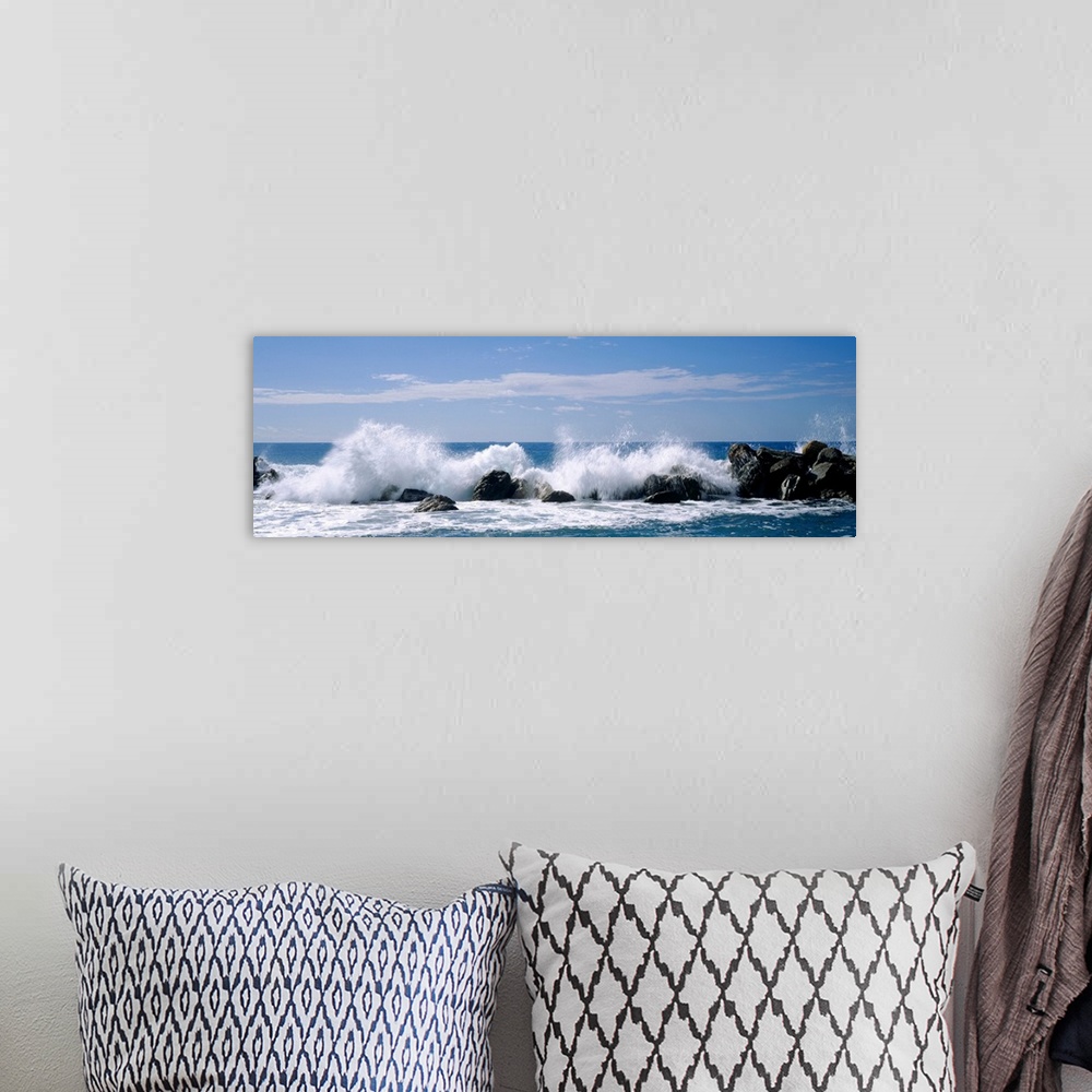 A bohemian room featuring Panoramic photograph of swells crashing against rocks under a cloudy sky.