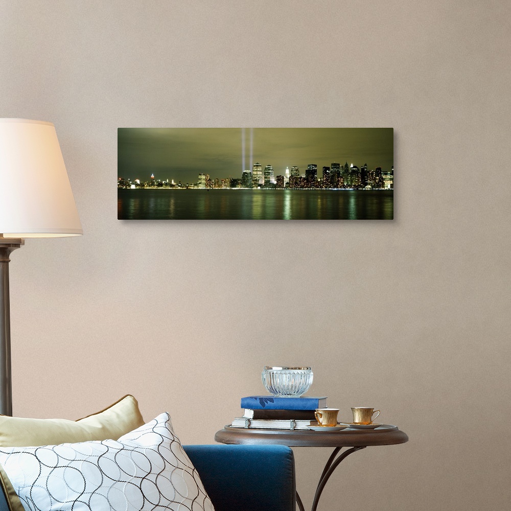 A traditional room featuring Panoramic cityscape on canvas of NYC lit up with two beacons of light shooting upwards in place o...