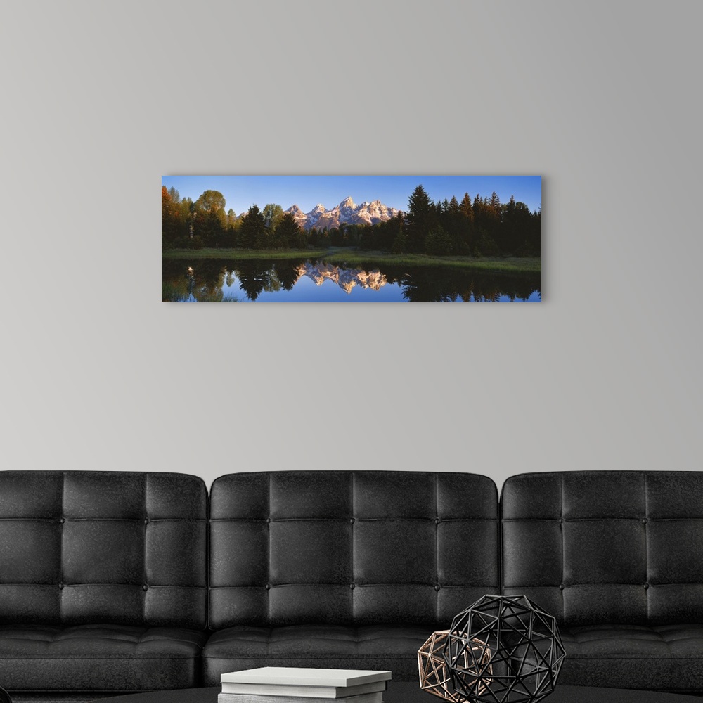 A modern room featuring Panoramic photo on canvas of a rugged mountain range in the distance of a tree line and a lake wi...
