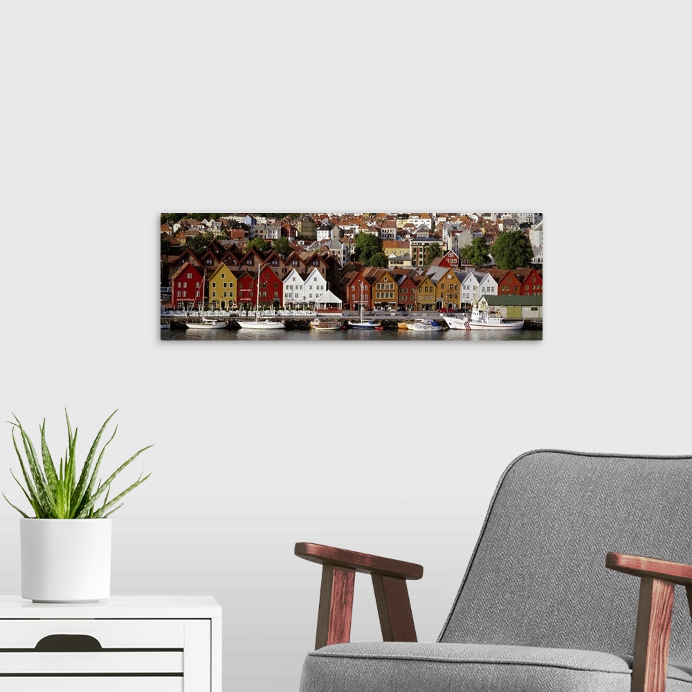 A modern room featuring This is a panoramic photograph of a coastal town in Northern Europe lining a harbor full of boats.