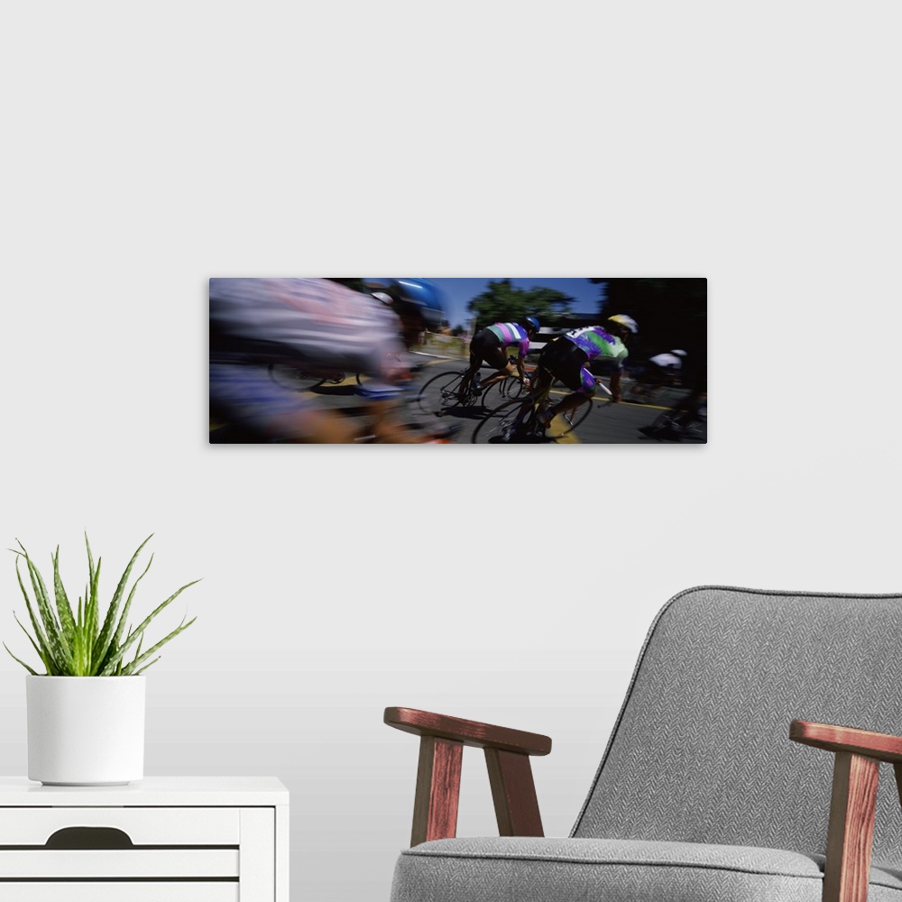 A modern room featuring Panoramic blur motion photograph of cyclists racing on the street.