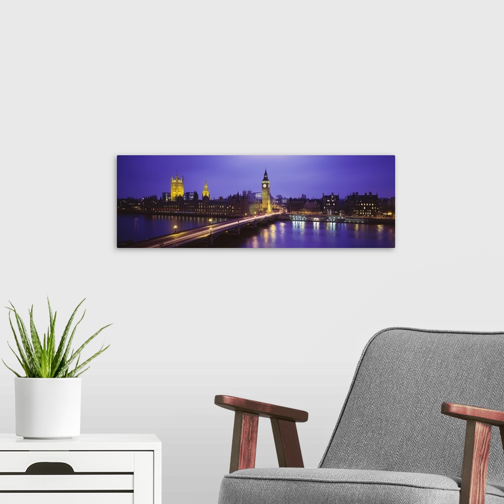 A modern room featuring Cityscape of London at twilight, showing light trails from traffic along the bridge and lights fr...