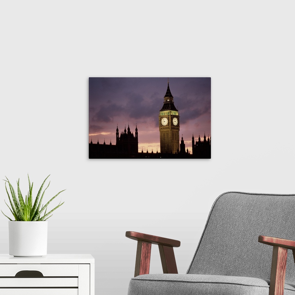 A modern room featuring A lit up Big Ben clock exends in to the dusk London sky rising high above the spires of Parlament...