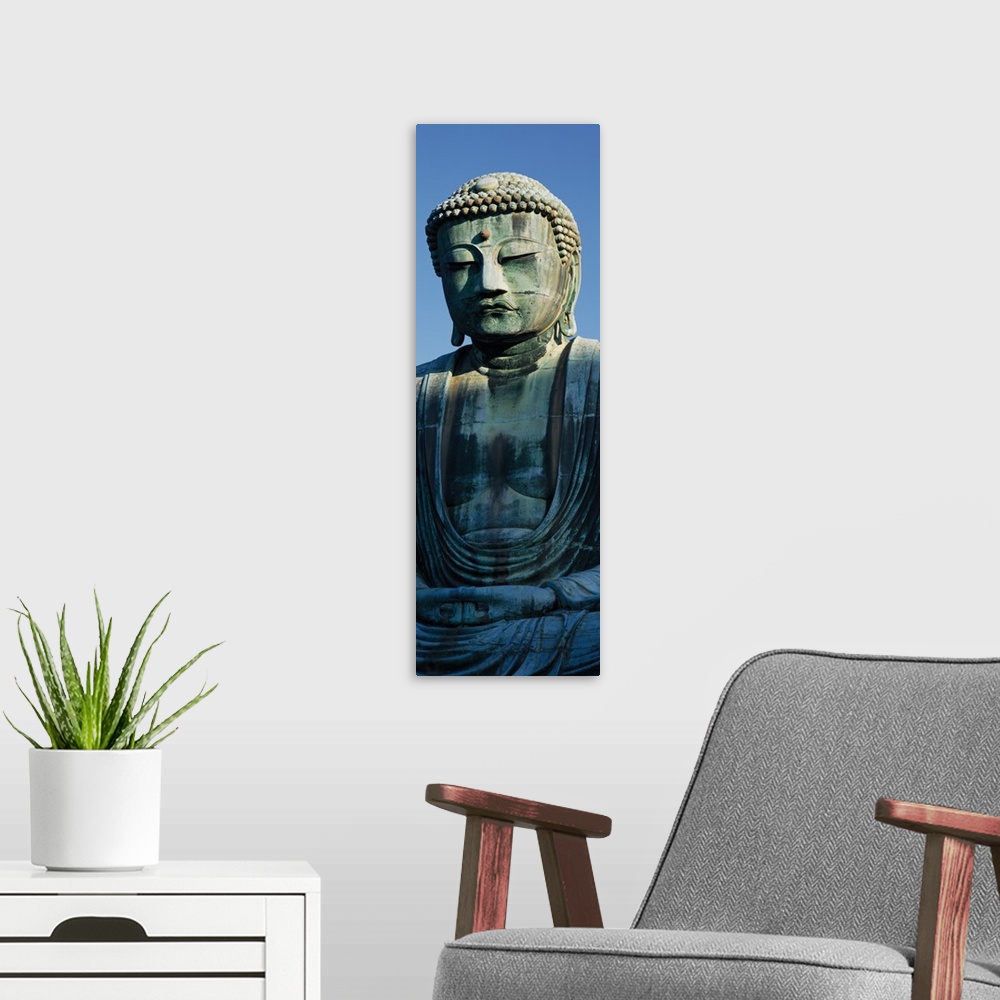 A modern room featuring Only part of a Buddha statue is photographed for this tall panoramic piece.