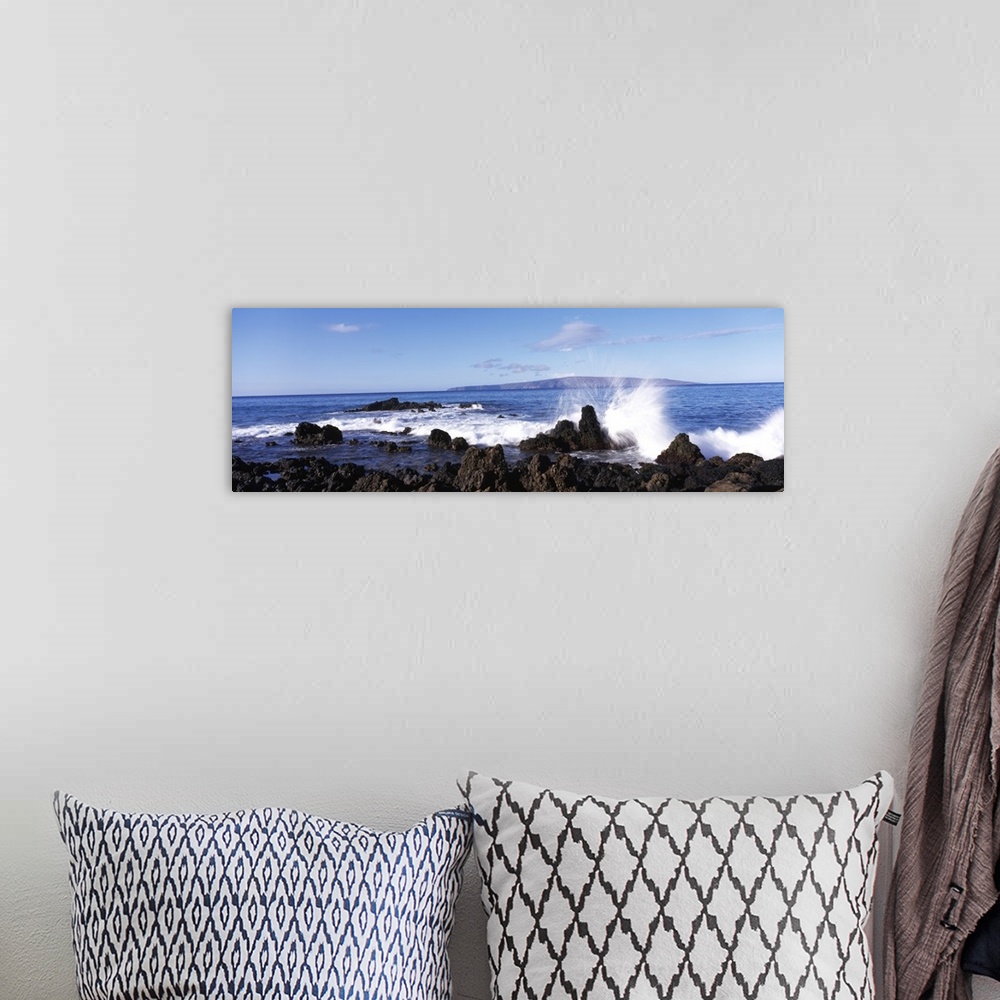A bohemian room featuring This panoramic photograph shows a wave breaking on the volcanic rock on the island shore.