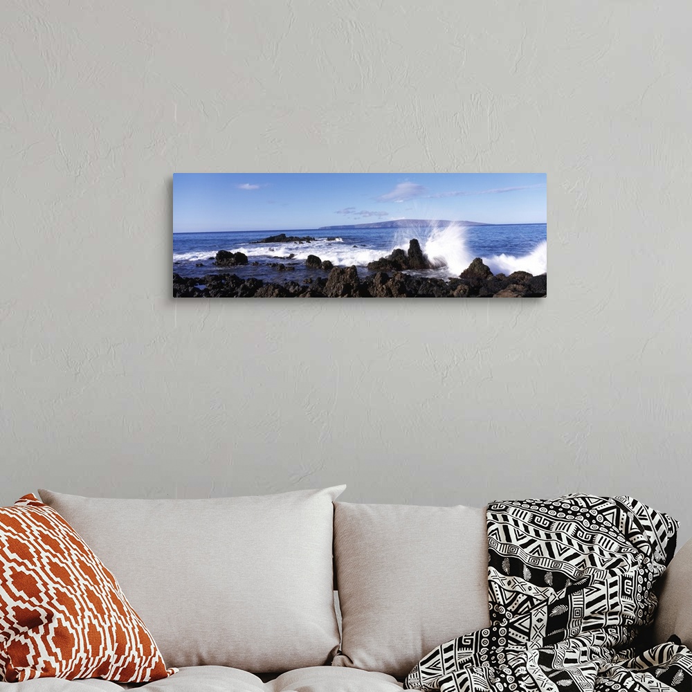 A bohemian room featuring This panoramic photograph shows a wave breaking on the volcanic rock on the island shore.