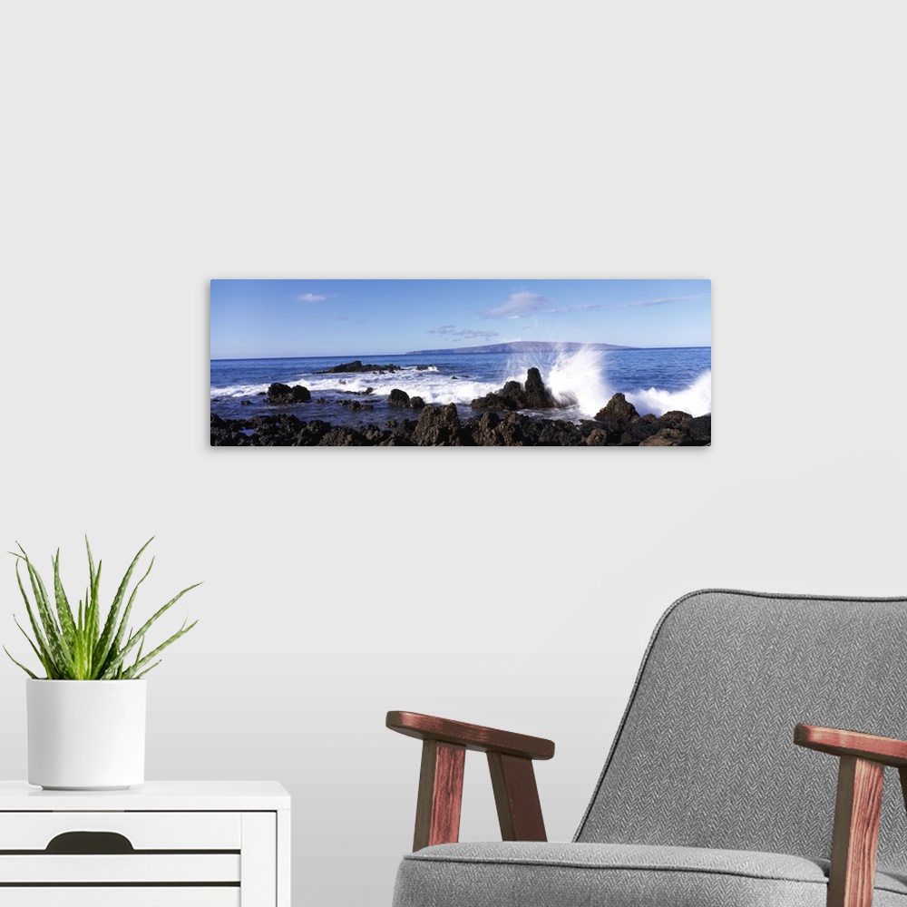 A modern room featuring This panoramic photograph shows a wave breaking on the volcanic rock on the island shore.