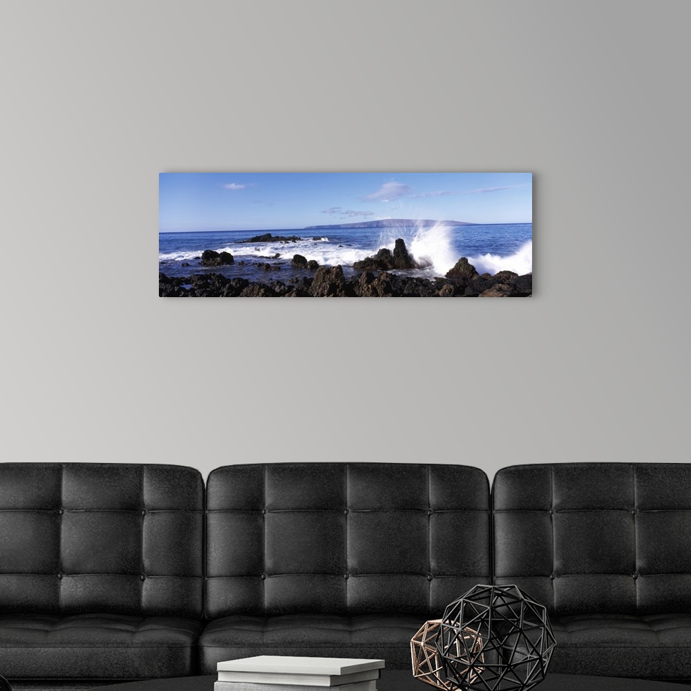 A modern room featuring This panoramic photograph shows a wave breaking on the volcanic rock on the island shore.