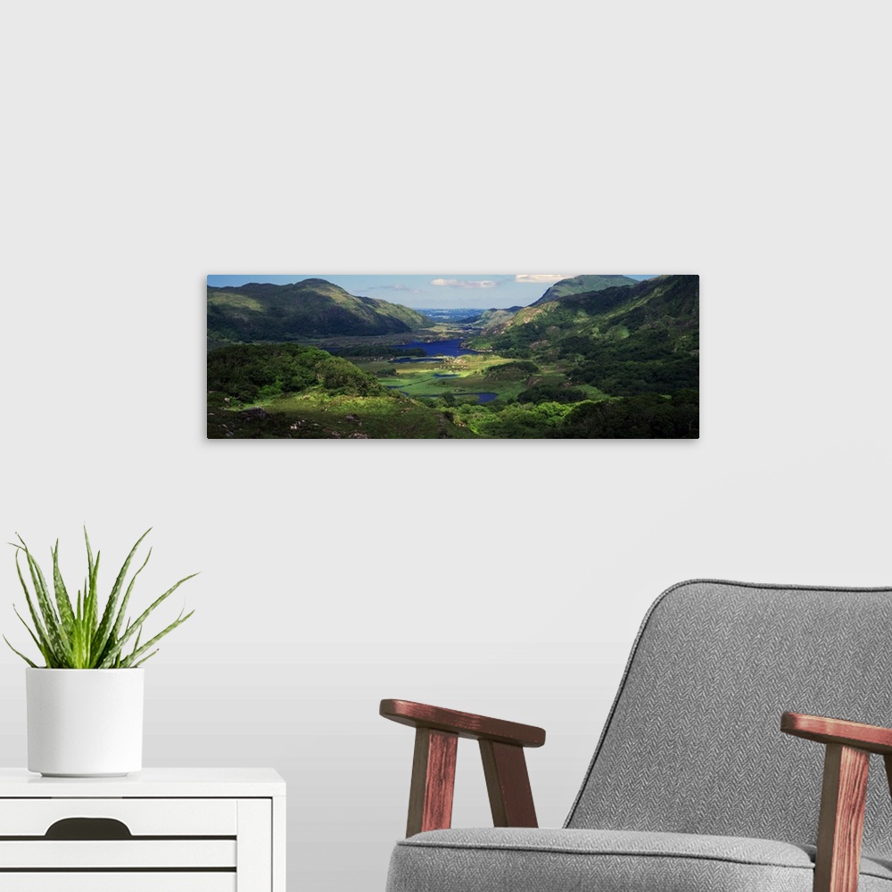 A modern room featuring View of an Irish valley with a stream running through the lush green landscape between the rollin...