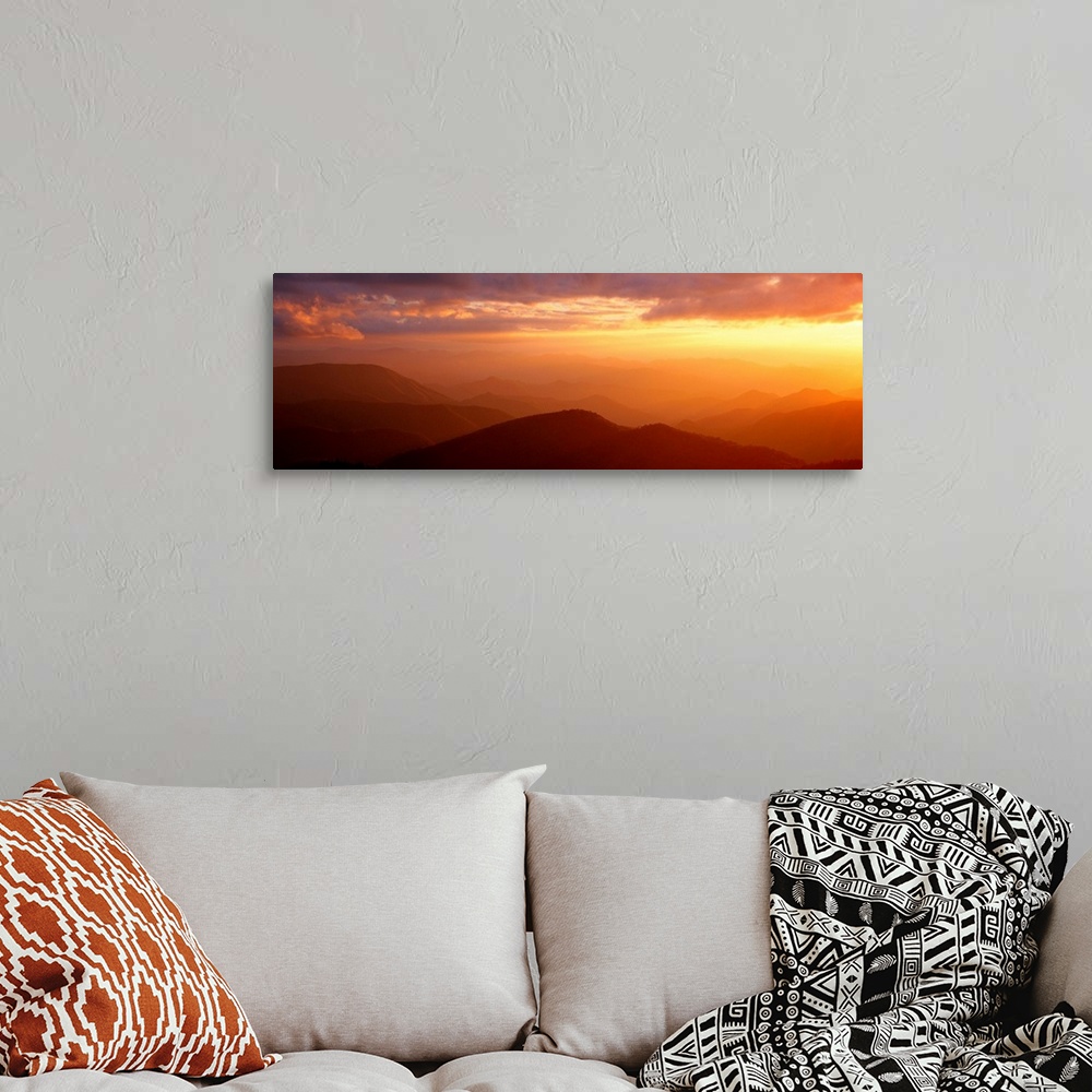 A bohemian room featuring Panoramic photograph shows the glow of the sun as it begins to set on a mountain range within Nor...
