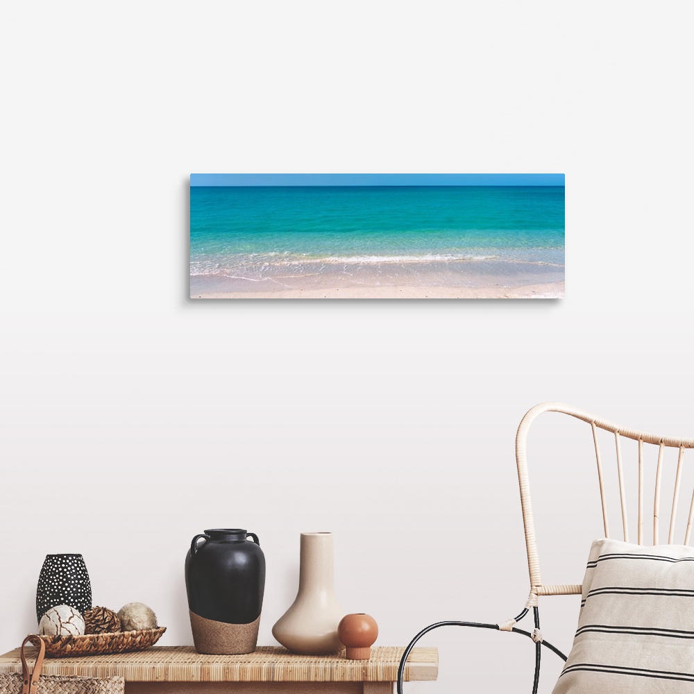 A farmhouse room featuring A panoramic photograph of a calm sea of tropical colored water.