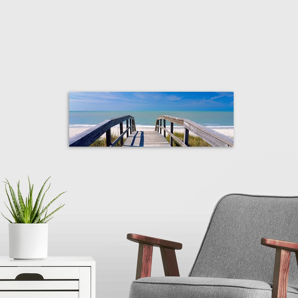 A modern room featuring Wall art for the home or office this panoramic photograph shows a boardwalk over dunes to a sandy...