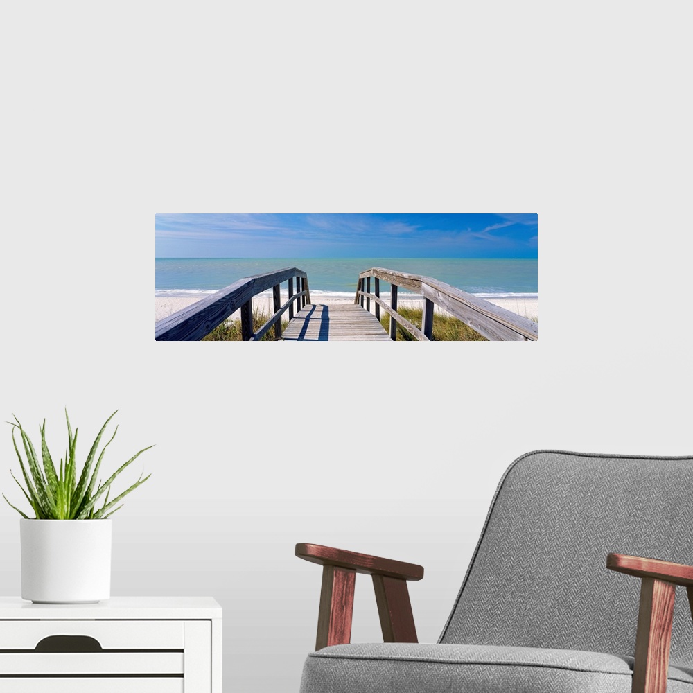 A modern room featuring Wall art for the home or office this panoramic photograph shows a boardwalk over dunes to a sandy...