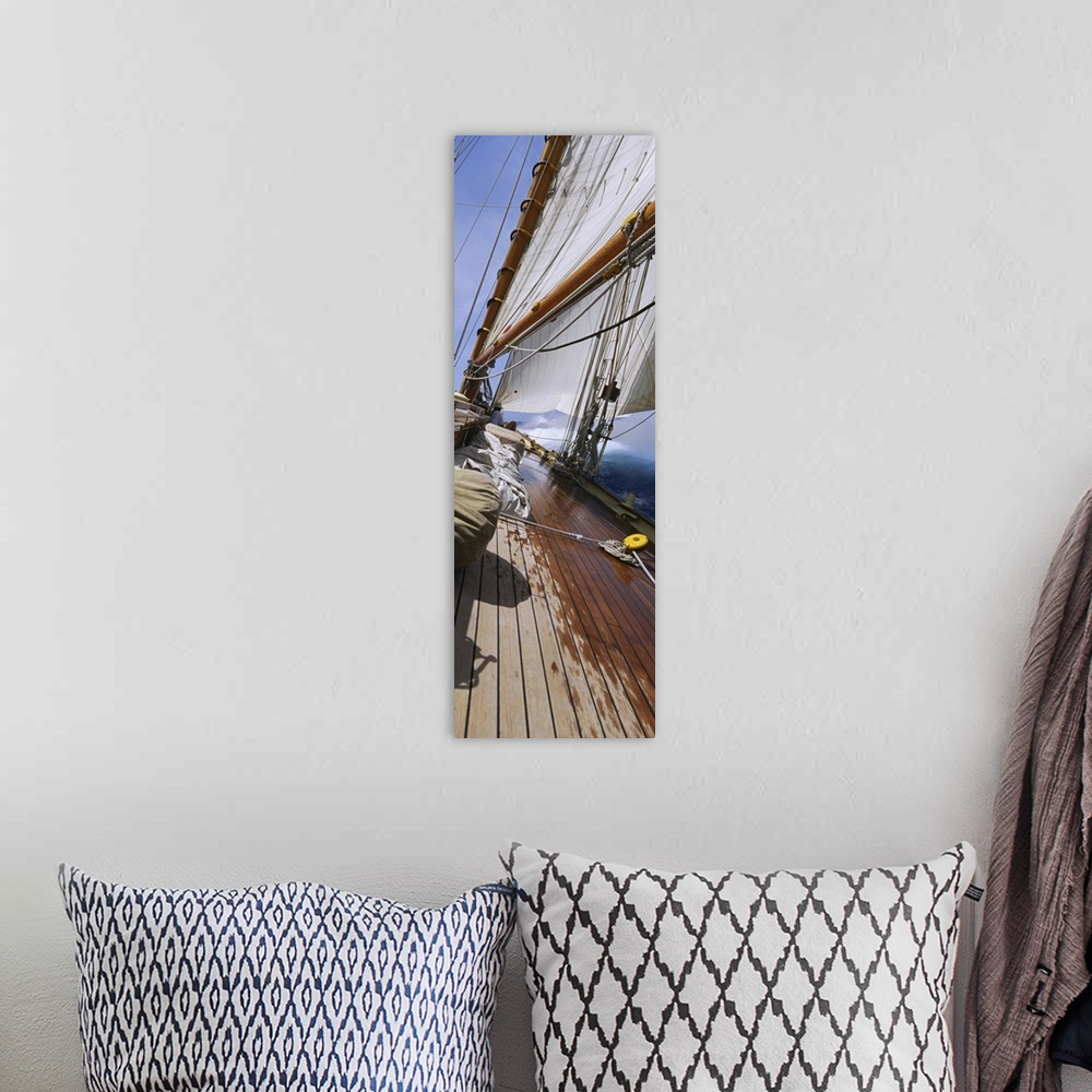 A bohemian room featuring Vertical panorama of the deck of a sail boat as it tips starboard in water with the sails at full...