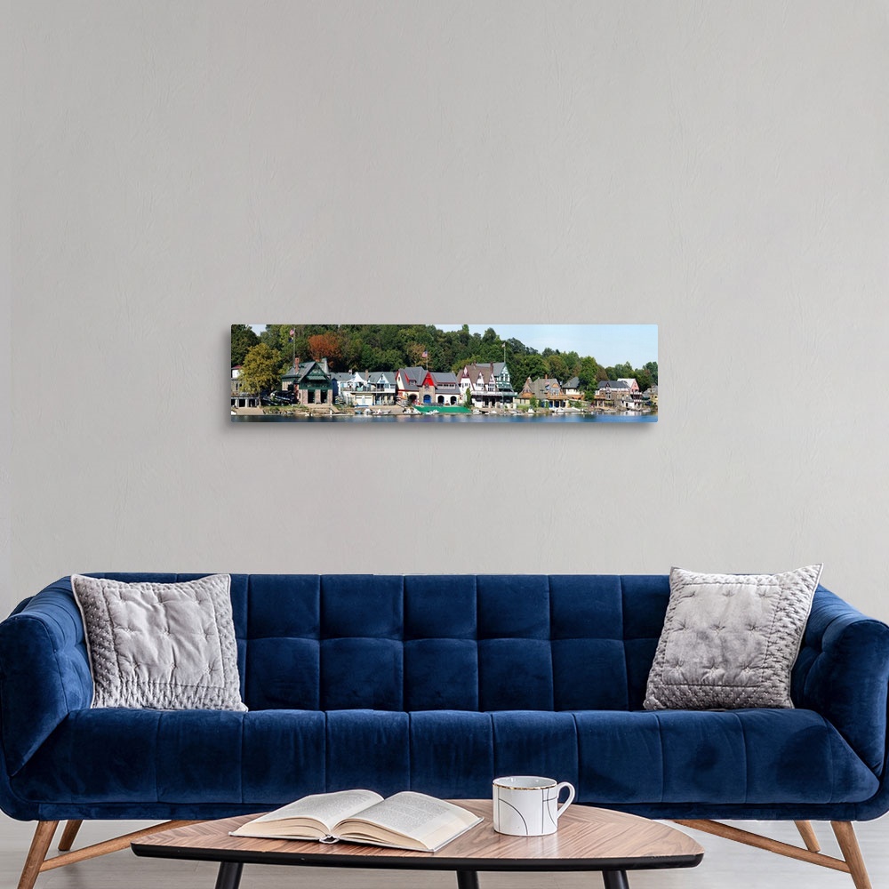 A modern room featuring A panoramic photograph taken at midday in late summer of the boat houses that line the river.