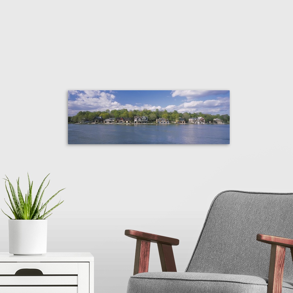 A modern room featuring Panoramic photo of boathouses lining a waterfront.
