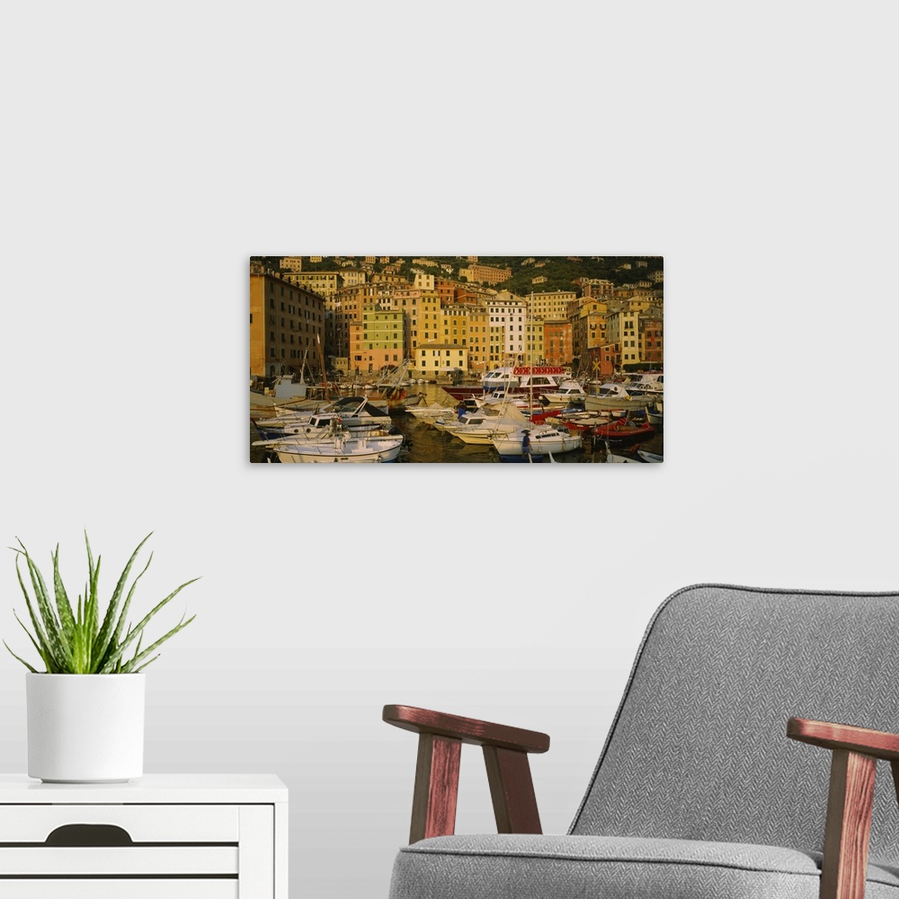 A modern room featuring Big canvas photo art of boats in the harbor with tall buildings on a hill in the background reach...