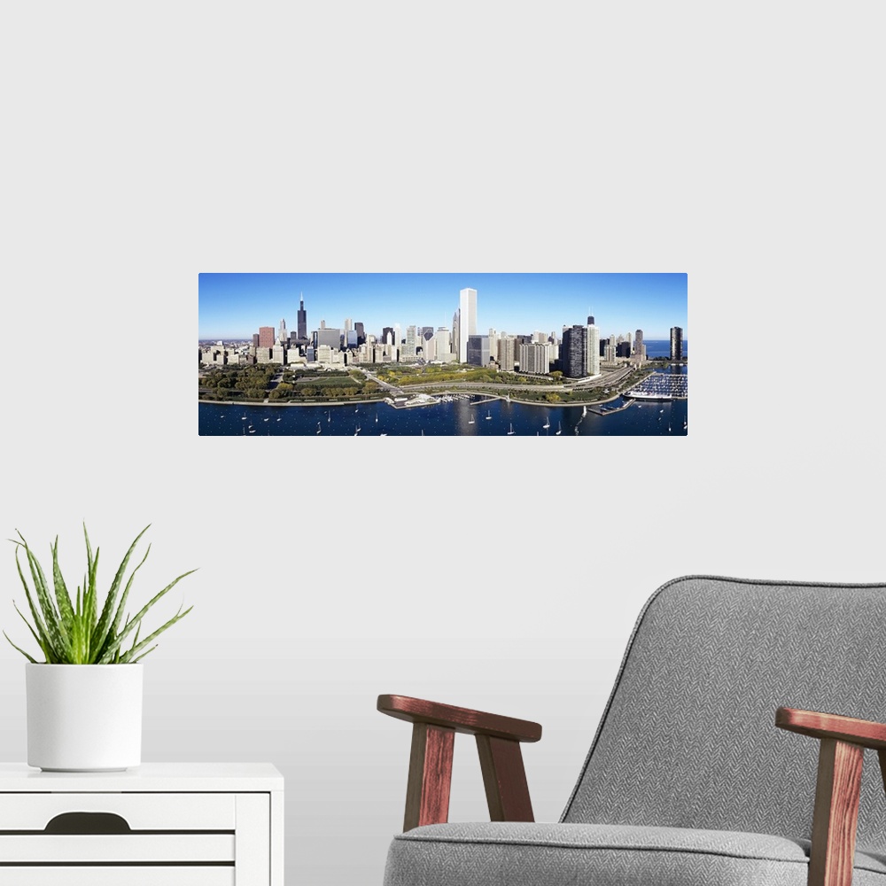 A modern room featuring A large panoramic photograph taken of a harbor in Chicago with multiple boats anchored in the wat...