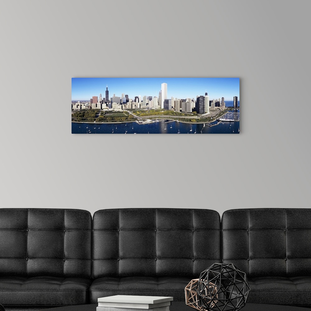 A modern room featuring A large panoramic photograph taken of a harbor in Chicago with multiple boats anchored in the wat...