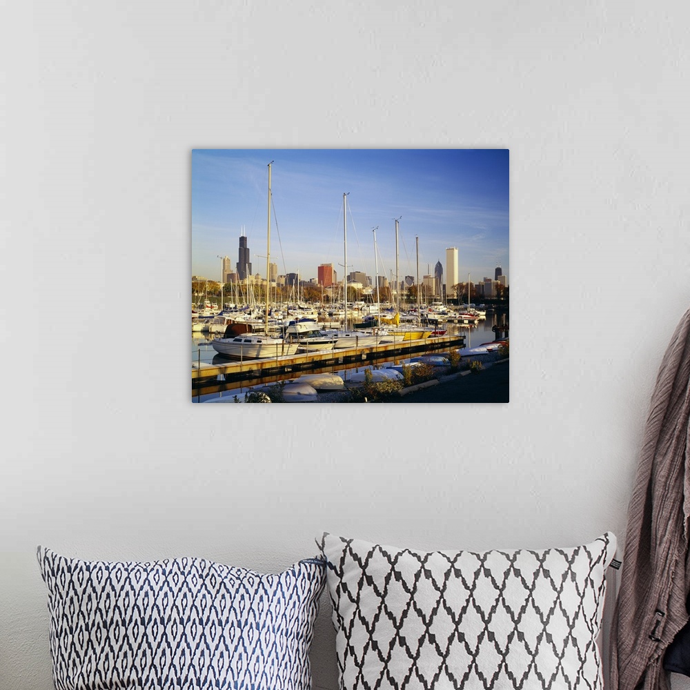 A bohemian room featuring This oversize piece is a picture taken of a line of boats docked in the waterfront near Chicago.
