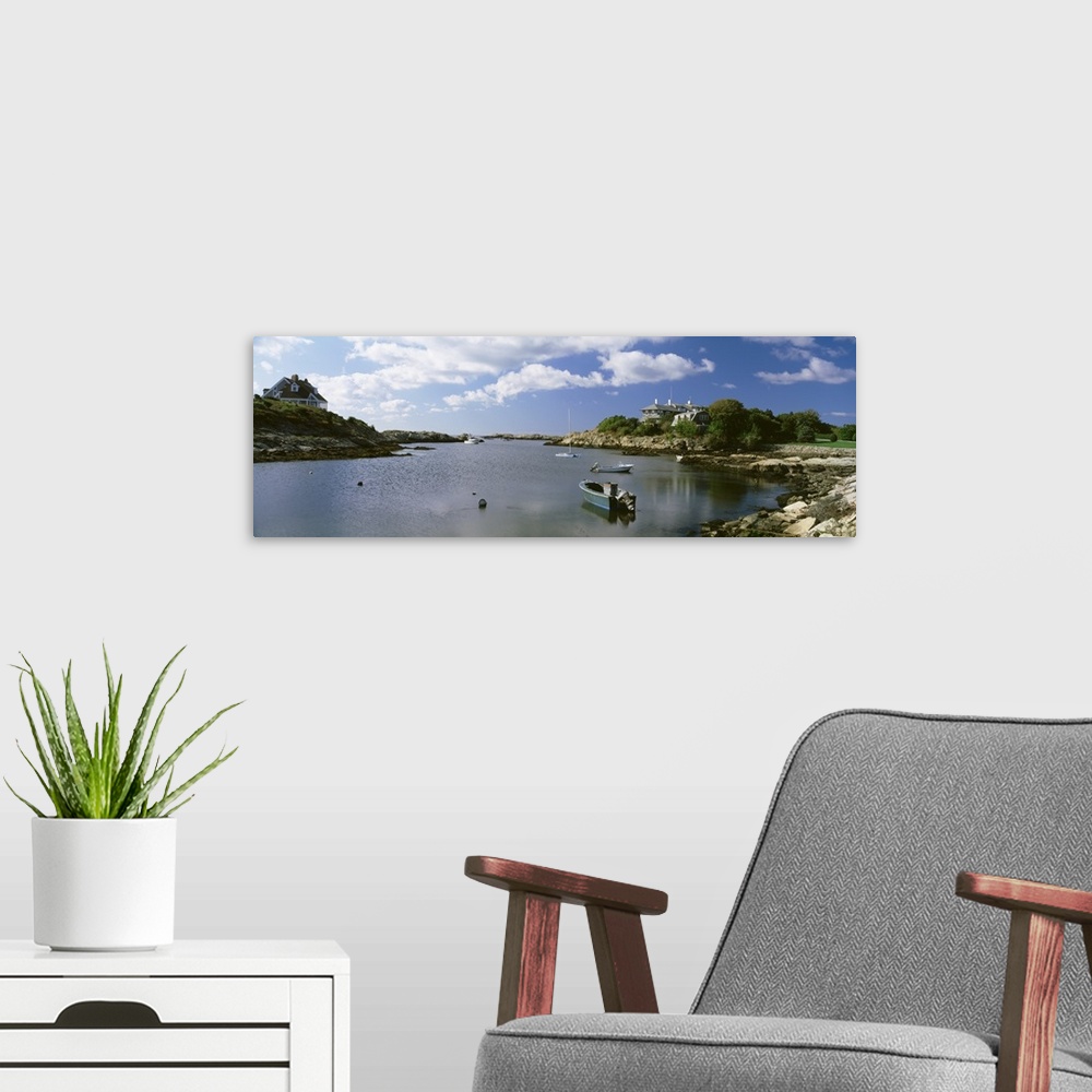 A modern room featuring Panoramic photograph on a big canvas of several small boats in ocean water, surrounded by rocky l...