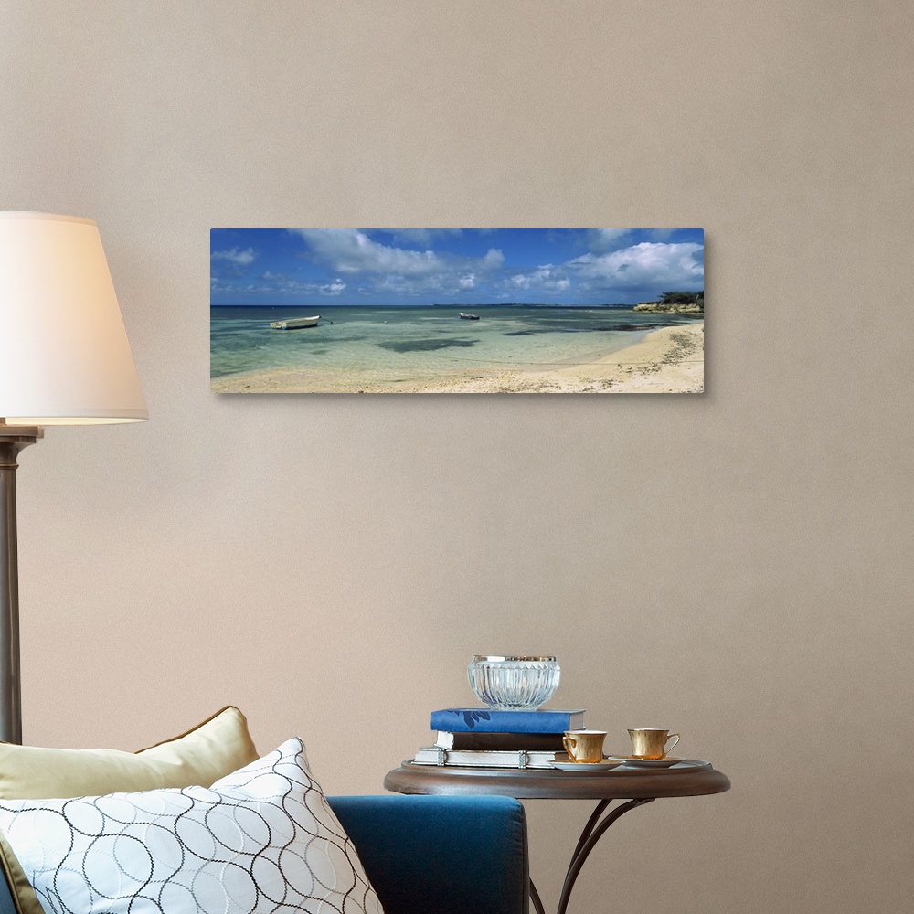 A traditional room featuring Long horizontal image on canvas of boats floating in the ocean near a shore.