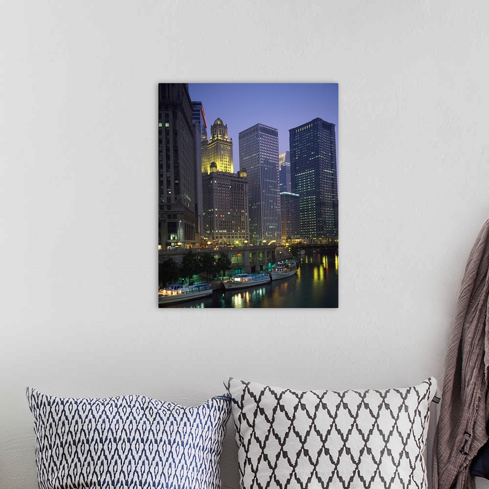 A bohemian room featuring Portrait photograph on a big wall hanging of lit skyscrapers towering over the edge of the Chicag...