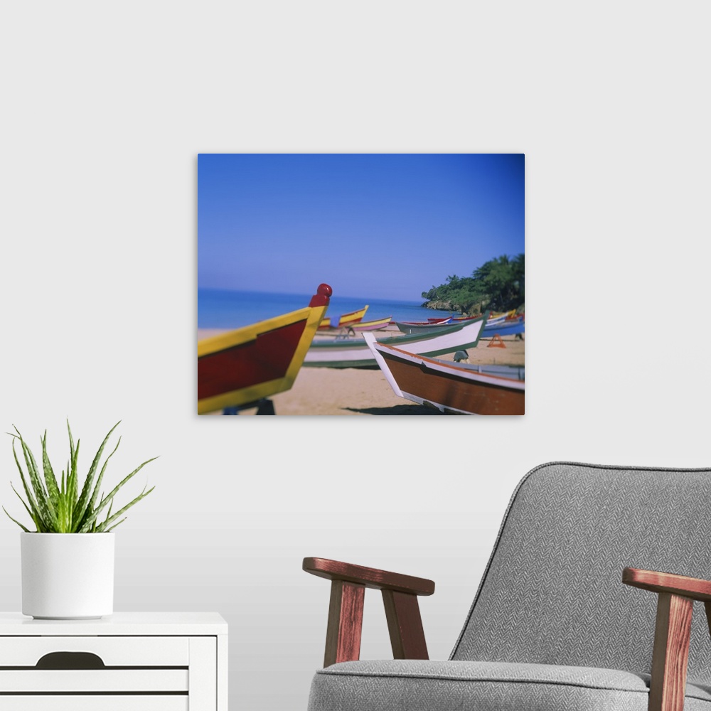 A modern room featuring Big canvas photo of colorful wooden boats sitting on a beach with an ocean in the background.
