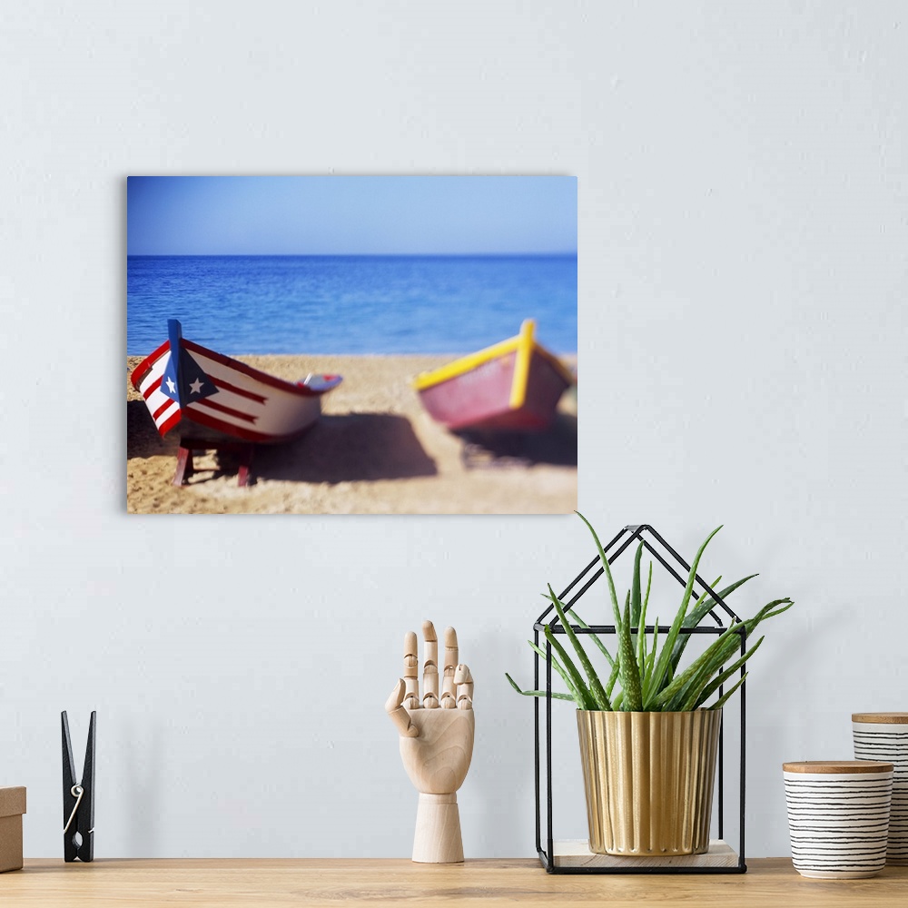 A bohemian room featuring Large, landscape photograph of several small wooden boats on the beach, the closest boat in focus...