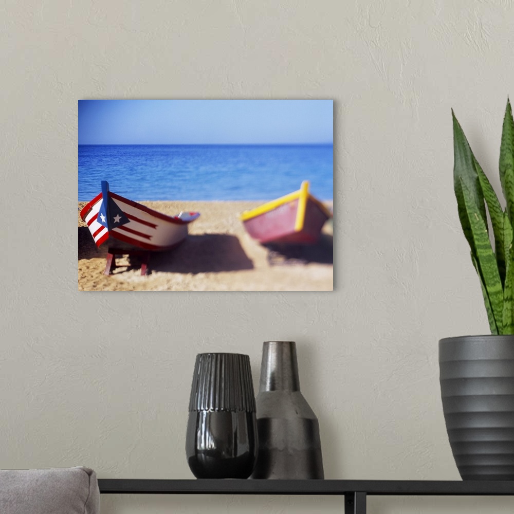 A modern room featuring Large, landscape photograph of several small wooden boats on the beach, the closest boat in focus...