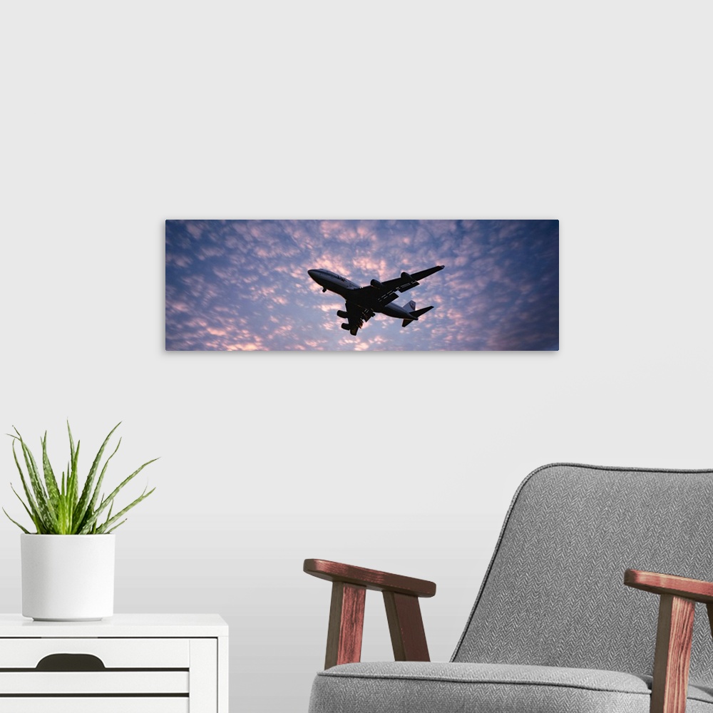 A modern room featuring Panoramic photograph showcases the near silhouette of a wide-body commercial airliner and cargo t...