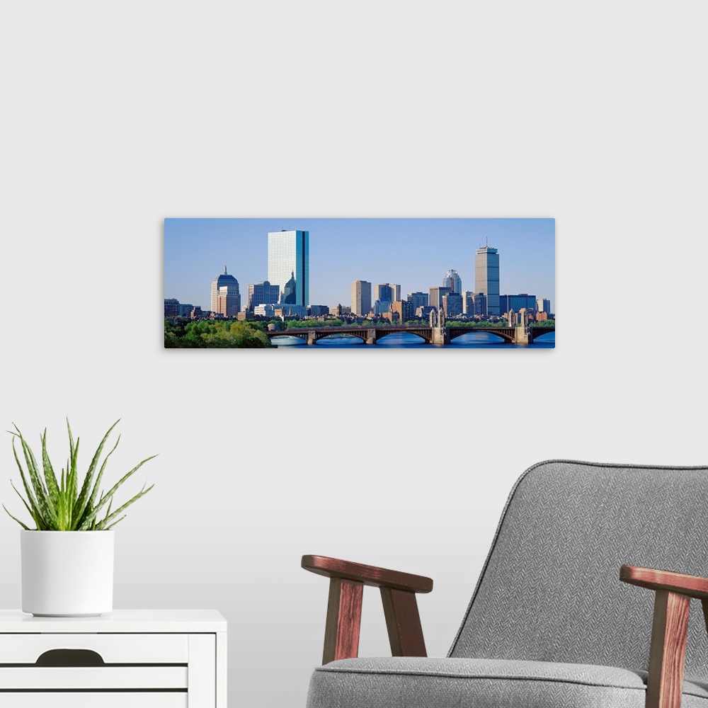 A modern room featuring This wall art is a panoramic photograph of the city skyline over the water taken in the middle of...