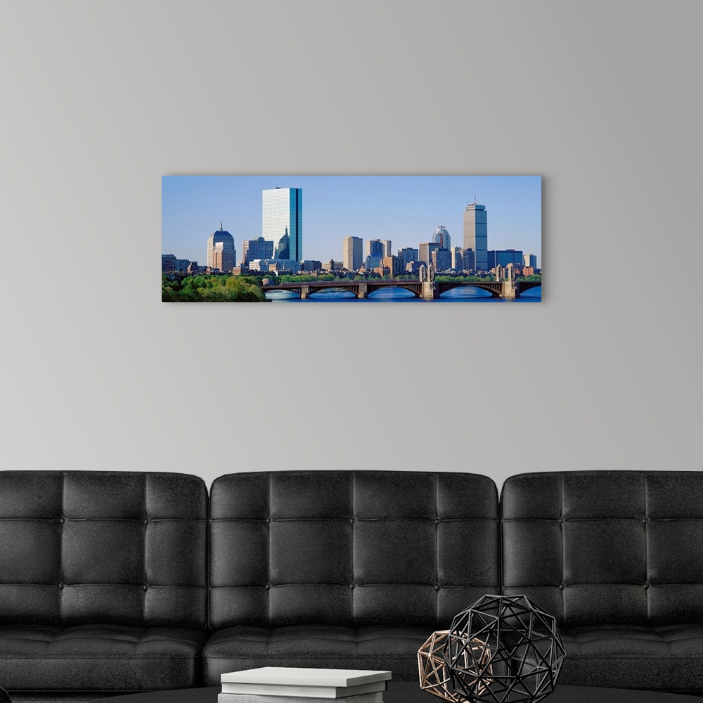A modern room featuring This wall art is a panoramic photograph of the city skyline over the water taken in the middle of...
