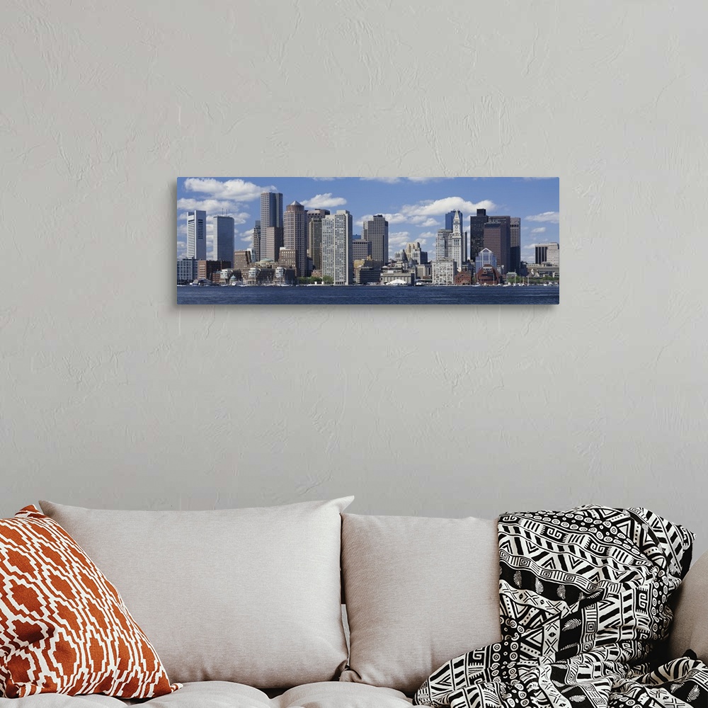 A bohemian room featuring Panoramic big canvas print of a cityscape along a water front with a blue sky with puffy clouds i...