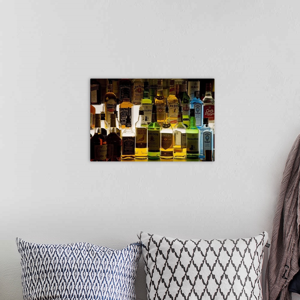 A bohemian room featuring Photograph of glass bottles full of different kinds of alcohol such as Jack Daniels, Powers, Famo...