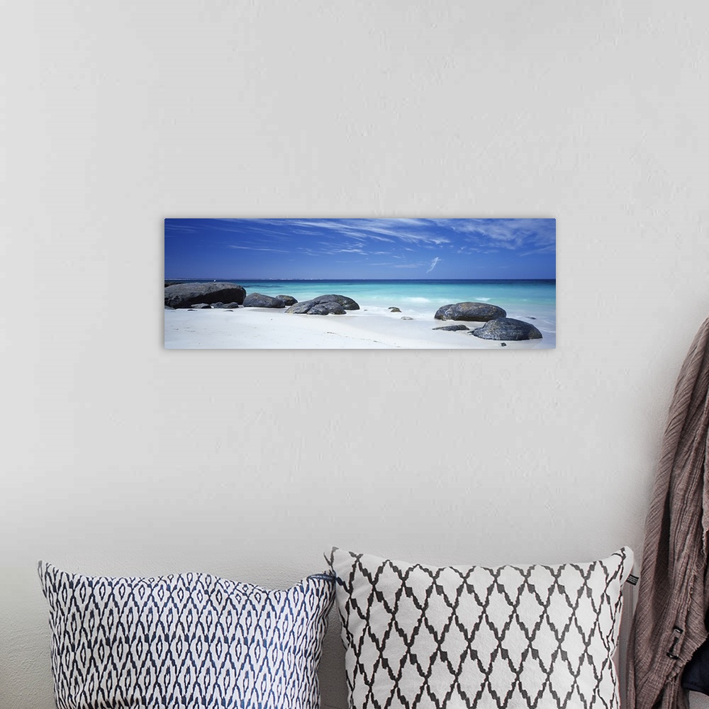 A bohemian room featuring Wide angle photograph on a large canvas of big rocks on a white sand beach near the crystal blue ...