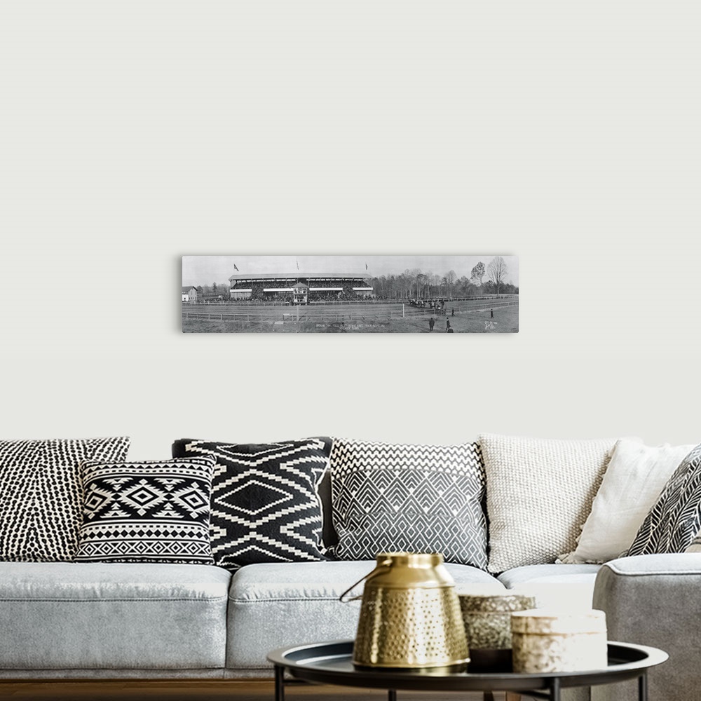 A bohemian room featuring Panoramic vintage photograph of race track with people filled stands on the side.