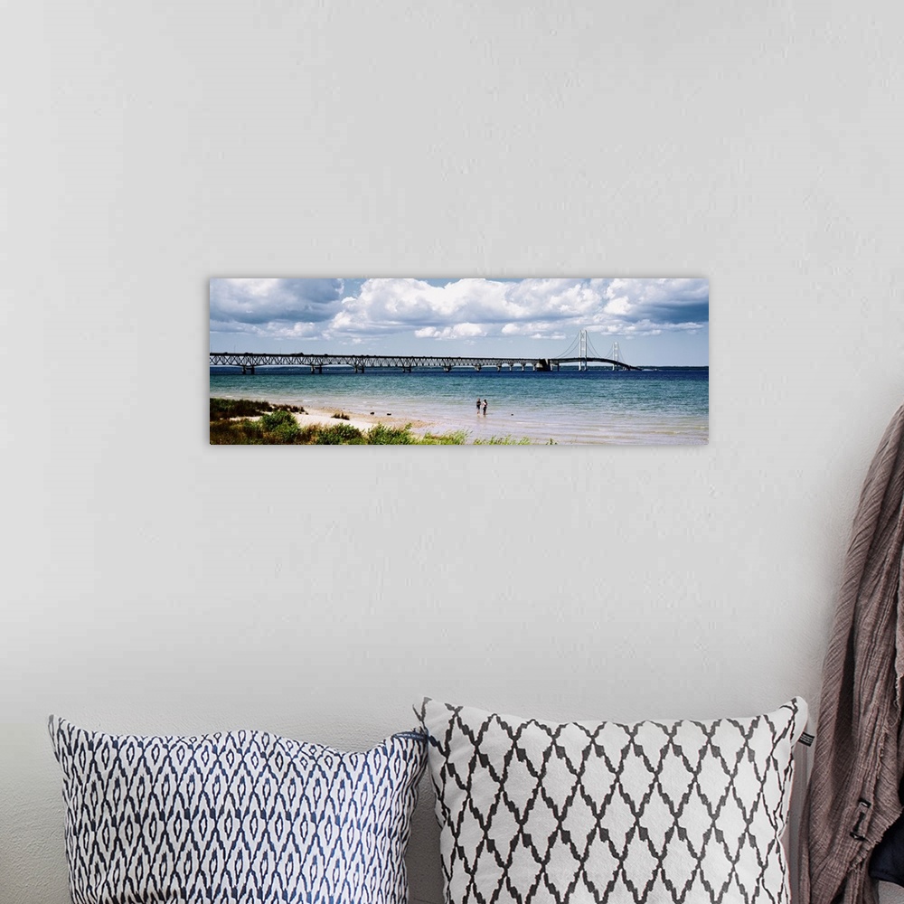 A bohemian room featuring Panoramic picture of a massive bridge that stretches across a lake in Michigan. Some beach on the...